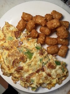 Fresh veggie omelet with crispy tater tots served at Fast Bagel, New Jersey – the perfect post-Halloween breakfast idea