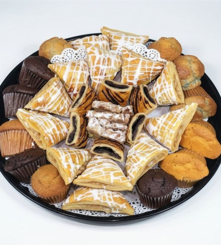 Breakfast catering spread with assorted pastries and muffins for an office meeting.